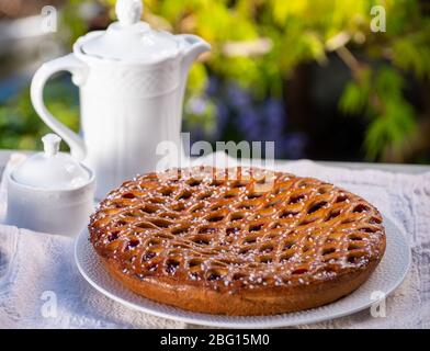 Kirschkuchen mit Teiggitter aus Limburg, Niederlande serviert in sonnigen Garten Stockfoto