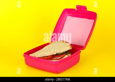 Lunchbox mit Sandwich auf gelbem Hintergrund Stockfoto