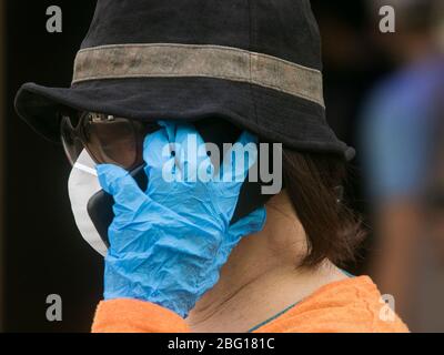 Beirut, Libanon. 20. April 2020. Eine Frau, die während der Coronavirus-Pandemie eine chirurgische Maske und Handschuhe gegen Covid-19-Infektionen trägt, während sie ein Mobiltelefon hält. Der Libanon bleibt bis zum 26. April 2020 in der Blockierung, da die Regierung die Bürger dringend aufgefordert hat, zu Hause zu bleiben und nur für wichtige Geschäfte zu gehen. Kredit: amer Ghazzal/Alamy Live News Stockfoto