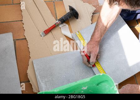 Der fliesenleger Maßnahmen die Fliesen vor dem Schneiden Stockfoto