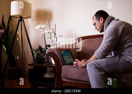 Kocaeli/Türkei - 17. April 2020: Junger Mann, der als Home Office arbeitet, das auf der ganzen Welt immer beliebter wird. Arbeiten mit einer Tasse Kaffee zu Hause. Stockfoto