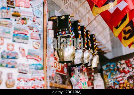 schweizer Souvenirs Glocken und Magnete mit Postkarten aus der schweiz. Schweizer Glocken. Stockfoto