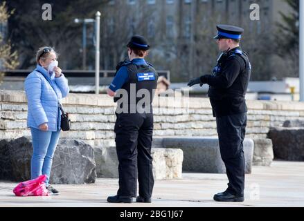 Polizeibeamte der Community Support unterstützen einen Bewohner von Weston-super-Mare mit Rat während der CV-Sperrung (**Hinweis - der Bewohner hatte nicht gegen Regeln verstoßen**) Stockfoto