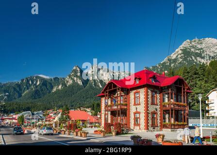 Rathaus in Bulevardul Libertatii in Busteni, Bucegi Berge mit Caraiman Gipfel auf der rechten Seite, Südkarpaten (Siebenbürgischen Alpen), Rumänien Stockfoto