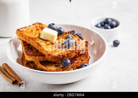 Französische Toasts mit Heidelbeeren und Honig in einem weißen Teller. Stockfoto