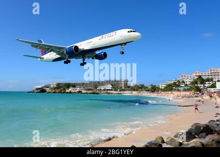 Delta Airlines Boeing 757 über Maho Beach, berühmt für die Flugzeuge, die sehr niedrig passieren, auf dem Flughafen St. Maarten landen. Touristenattraktion. Stockfoto