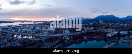 Luftdrohne-Aufnahme des Pendlerverkehrs auf der zweiten Narrows-Brücke und den Industriehafen in Vancouver, BC, Kanada bei Sonnenuntergang. Stockfoto