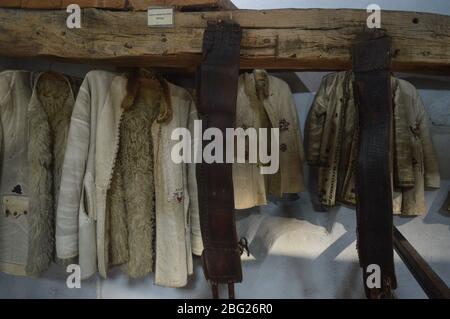 Traditionelle rumänische Lammfellmäntel und breite Bauerngürtel aus Leder in einem historischen ethnographischen Museum. Stockfoto