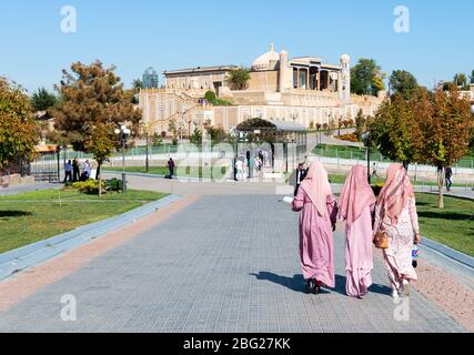 Gruppe von usbekischen einheimischen muslimischen Frauen in traditioneller Kleidung wie Schal und lange Kleidung. Blick auf den Alltag in Samarkand, Usbekistan. Stockfoto