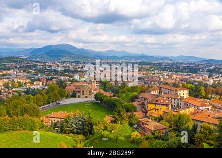 Luftaufnahme von Bergamo Stadt, Lombardei, Italien. Bergamo Alpen (Alpi Orobie) beginnen unmittelbar nördlich der Stadt, im Hintergrund. Malerischer Herbst vi Stockfoto