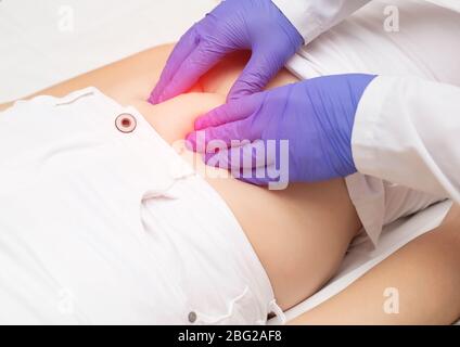 Der Arzt untersucht den Darm des Patienten mit Bauchtastungen. Das Konzept der Blähungen des Darms, Blähungen und Darmobstr Stockfoto