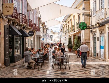 Gäste können das warme portugiesische Wetter genießen, während sie im Freien in der Fußgängerzone im Zentrum von Faro speisen. Stockfoto