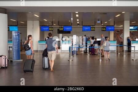 Touristen, die zum Check-in-Schalter von British Airways am internationalen Flughafen Faro, Portugal, laufen. Stockfoto