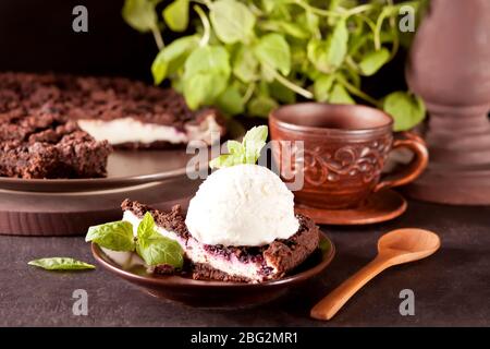 Cremiger Käsekuchen mit Schokolade, schwarzer Johannisbeere, Eis und Minzblatt zur Dekoration Stockfoto