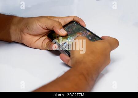 Hände spielen auf Handys Stockfoto