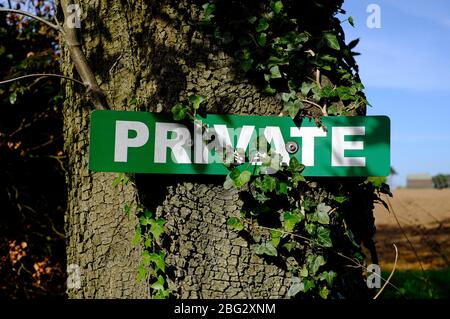 Privates Schild an Baumstamm auf Ackerland geschraubt, norfolk, england Stockfoto