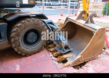 Schwere Straßenbaumaschinen, Vorderrad, großer Reifen und ein Ladereimer. Stockfoto