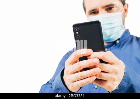 Mann in medizinischer Maske auf Smartphone auf weißem Hintergrund Stockfoto