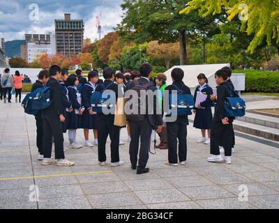Eine Gruppe von Schulkindern mit einem Lehrer auf einer Reise in den Hiroshima Peace Park, um mehr über die Geschichte der Atombomben am Ende des Weltkrieges zu erfahren Stockfoto