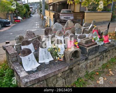 Jizo Statuen mit eingeschriebenen weißen Stoffschürzen entlang des Philosophenspaziergangs in Kyoto - Jizo ist die buddhistische Schutzgottheit von Kindern und Reisenden Stockfoto