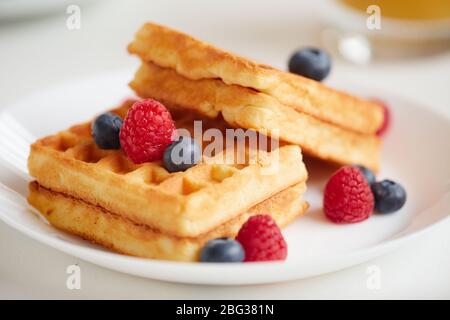 Minimale Zusammensetzung der süßen Dessert Waffeln mit Beere Belag über weißen Teller auf Café-Tisch gelegt, kopieren Raum Stockfoto