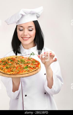 Schöne Mädchen Chef-Herd mit Pizza isoliert auf weiß Stockfoto