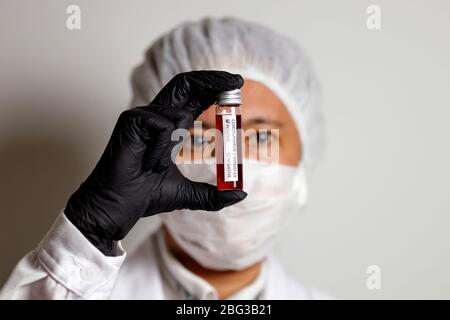 Nürnberg, Deutschland. April 2020. Ein Virologe posiert mit einer Korona-Blutprobe (Symbolto mit Modell).Verwendung weltweit Quelle: dpa/Alamy Live News Stockfoto