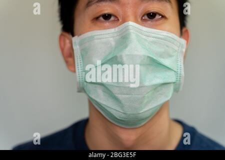 Porträt Nahaufnahme des asiatischen Mannes mit einer schützenden Gesichtsmaske gegen ansteckende Krankheit und Coronavirus. Schutz gegen Grippe, Influenza, Covid 19 Stockfoto