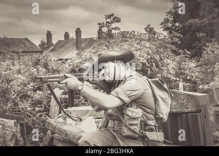 Altmodische, schwarz-weiße Nahaufnahme eines isolierten Soldaten im Freien mit einer Waffe, die auf das Black Country Museum zielt, Sommerveranstaltung im Zweiten Weltkrieg der 1940er Jahre, Großbritannien. Stockfoto