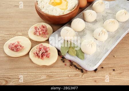 Rohe Knödel, Zutaten und Teig, auf Holztisch Stockfoto