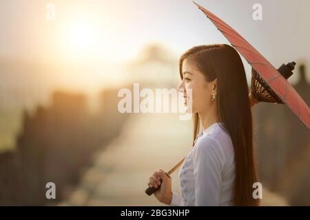 Porträt einer schönen Frau auf der Ubien-Brücke mit einem Sonnenschirm, Mandalay, Myanmar Stockfoto