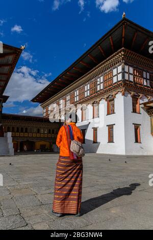 Rückansicht einer Frau in traditioneller Kleidung außerhalb Tashichho Dzong, Thimphu, Bhutan Stockfoto