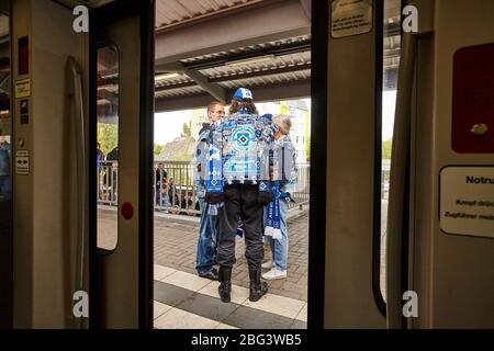 Eine Gruppe von Fußballfans des Hamburger Fußballteams HSV hat sich auf dem Bahnsteig vor der Tür der Stadtbahn beim Volksparkstadio gesehen Stockfoto