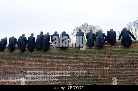 Eton, Windsor, Berkshire, Großbritannien. November 2010. Eton College Jungen sitzen auf einer hohen Mauer gebaut in 1717 neben dem Eton College Spielfelder, wie sie ihre Kollegen Schüler im Wettbewerb in der Wall Game. Das erste aufgezeichnete Wall Game wurde 1766 aufgenommen. Eton College ist eine gebührenpflichtige öffentliche Schule, die von vielen britischen Politikern wie Boris Johnson und David Cameron besucht wird. Prinz William und Prinz Harry besuchten auch Eton College. Kredit: Maureen McLean/Alamy Stockfoto