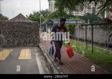 Kuala Lumpur, Malaysia. April 2020. Ein Mann versucht, Lebensmittel an seine Freunde in der Nähe von Pasar Borong Kuala Lumpur, Malaysia übergeben. Nach der Überwachung der Bereiche als verbesserte Bewegungskontrolle am 20. April 2020. Der malaysische Premierminister Muhyiddin Yassin hat am 10. April angekündigt, dass die "Kontrollordnung für die Bewegung" (MCO) vom 15. Bis 28. April verlängert wird, um die Ausbreitung des Coronavirus Covid-19 zu verhindern. Länder auf der ganzen Welt ergreifen verstärkt Maßnahmen, um das weit verbreitete SARS-CoV-2-Coronavirus, das die Covid-19-Krankheit verursacht, einzudämmen. (Foto von Zulfadhli Zaki/Pacific Press) Credi Stockfoto