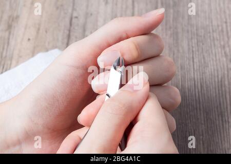 Eine Frau macht eine Maniküre zu Hause. Maniküre-Werkzeuge. Maniküre mit Kanten. Gefährliche Maniküre. Häusliche Pflege, Spa, Schönheit. Nagelstudio Stockfoto