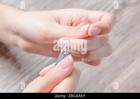 Eine Frau macht eine Maniküre zu Hause. Maniküre-Werkzeuge. Maniküre mit Kanten. Gefährliche Maniküre. Häusliche Pflege, Spa, Schönheit. Nagelstudio Stockfoto