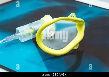 Sauerstoffmaske über den Röntgenfilmen der Brust. Covid-19 Ausbruch und Lungenentzündung. Stockfoto