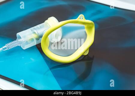 Sauerstoffmaske über den Röntgenfilmen der Brust. Covid-19 Ausbruch und Lungenentzündung. Stockfoto