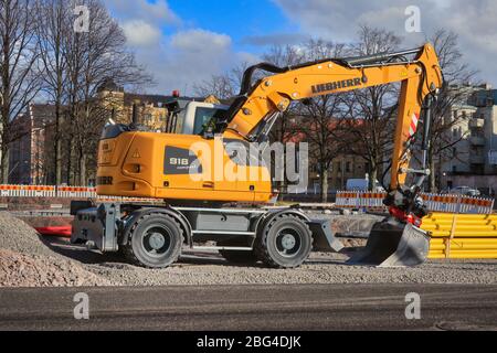 Neuer Liebherr EIN kompakter Mobilbagger 918 auf dem Straßenbaugelände in Helsinki, Finnland. Verlegung von wegseifendem Rohr. Helsinki, Finnland. 25. März 2020. Stockfoto