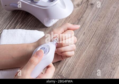 Eine Frau macht ihre eigene Hardware-Maniküre zu Hause. Nahaufnahme. Maniküre-Set. Gefährlich. Nägel. Häusliche Pflege, Salon, Spa, Schönheit, Gesundheit. Russische Maniküre Stockfoto