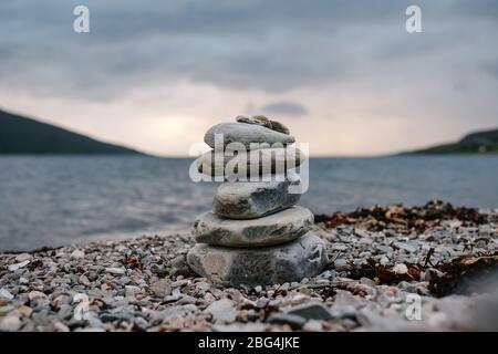 Kleiner Steinhaufen oder ein Steinhaufen am Ufer des Loch Broom in Ullapool im West Highlands von Schottland. Stockfoto