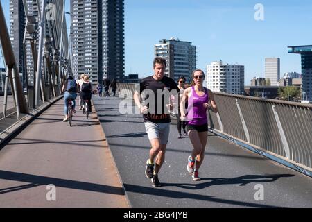 Jogger auf der Erasmus-Brücke in Rotterdam, Niederlande. Der berühmte Marathon von Rotterdam wurde wegen der Corona-Krise abgesagt. Stockfoto