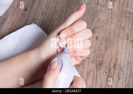 Eine Frau macht ihre eigene Hardware-Maniküre zu Hause. Maniküre-Set. Gefährlich. Nägel. Häusliche Pflege, Salon, Spa, Schönheit, Gesundheit. Russische Maniküre Stockfoto