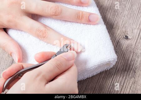 Eine Frau macht eine Maniküre zu Hause. Maniküre-Werkzeuge. Maniküre mit Kanten. Gefährliche Maniküre. Häusliche Pflege, Spa, Schönheit. Nagelstudio Stockfoto