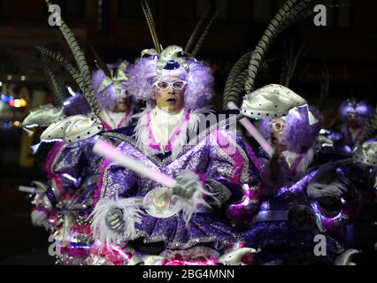 AALST, BELGIEN, 23. FEBRUAR 2020: Unbekannter Mardi Gras Karnevalssteilnehmer in leuchtend lila beleuchteten Kostümentänzen in der jährlichen Parade. Die Straße Stockfoto