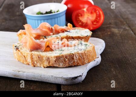 Fisch-Sandwiches auf dem Schneidebrett auf dem Holztisch Stockfoto