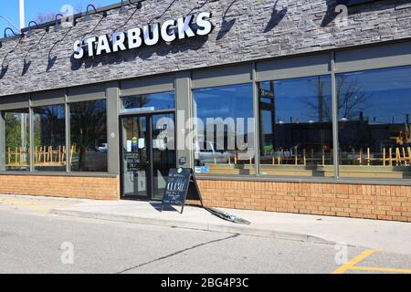 Starbucks Café in Cambridge, ON, Kanada, mit einem Schild, DASS WIR VORNE GESCHLOSSEN sind, und sichtbaren Stühlen auf dem Kopf. 'Durchstarten ist offen!' Stockfoto