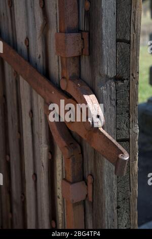 Antike Holztür mit rostigen Eisenbeschläge und Riegel. Stockfoto