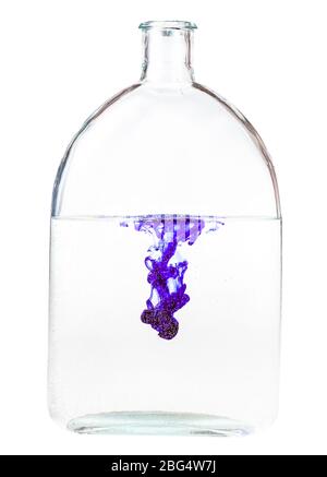 Violette Tinte löst sich in Wasser in Glasflasche auf weißem Hintergrund isoliert Stockfoto